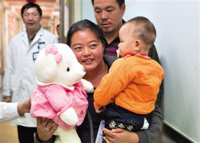 昨日上午，被扎針女嬰的母親抱著孩子和醫(yī)護(hù)人員送的玩偶準(zhǔn)備出院，院方稱孩子術(shù)后恢復(fù)良好。記者 高瑋 攝