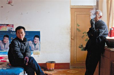 父親抽煙，兒子不語。逃跑的越南新娘，給袁迎賓父子帶來的是失落。新京報記者 周崗峰 攝