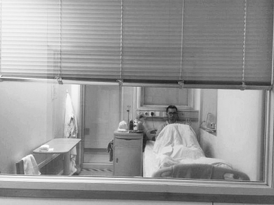 楊杰在醫(yī)院隔離病房中，沖記者揮了揮手。