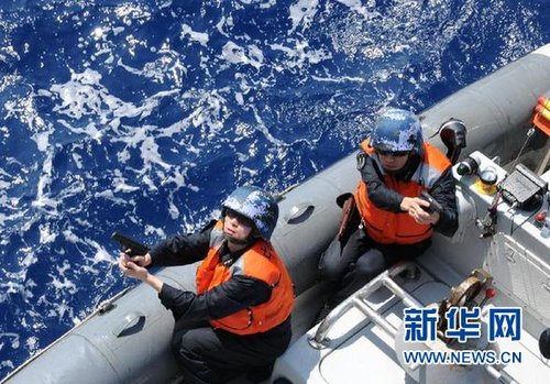 　3月28日，十余名臨檢拿捕隊員乘小艇駛至模擬可疑商船下方水面。