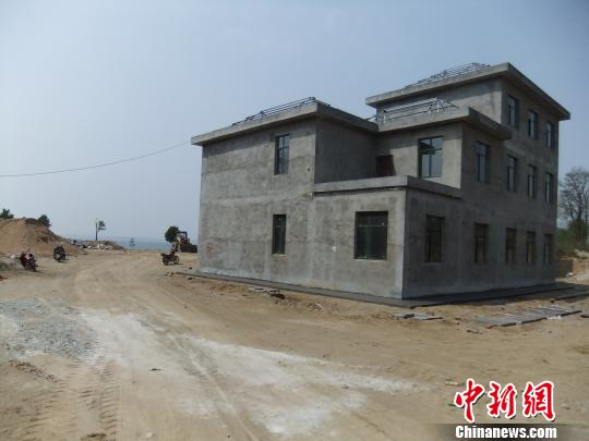 鴨河水庫庫區(qū)邊的新建別墅，一面墻上寫著“拆”，另一邊在加緊施工。吳揚　攝