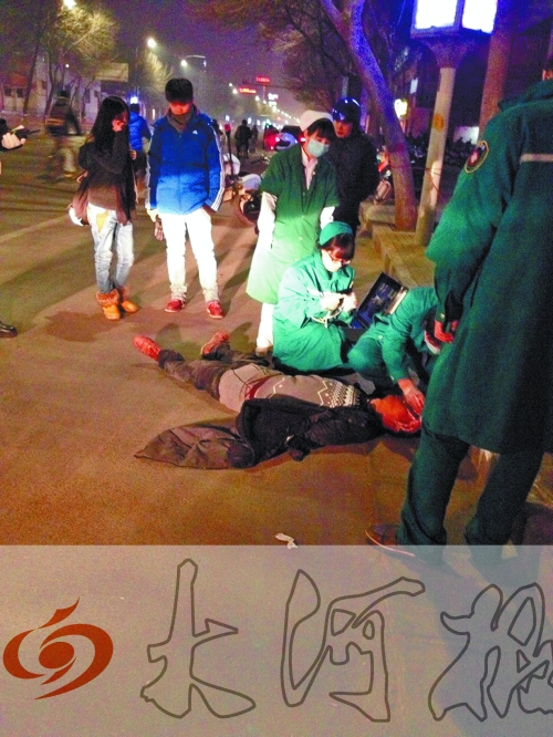 醉漢躺在地上，醫(yī)護(hù)人員對(duì)其進(jìn)行檢查。
